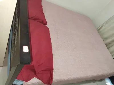 a bunk bed with red sheets on top of it at Mall Of Asia Sea Condotel in Manila