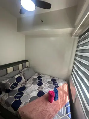 a bedroom with a bed with pink shoes on it at Leaf Residences Alabang Muntinlupa Condotel in Manila