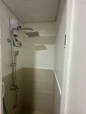 a bathroom with a shower with a shower head at Leaf Residences Alabang Muntinlupa Condotel in Manila