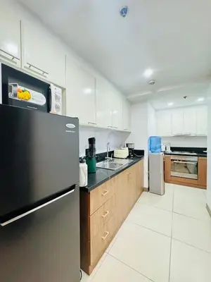 a kitchen with a refrigerator and a sink at Venetian Panorama BGC Venice Grand Canal Apart ment, 4 Bedrooms, for 10 Guests in Manila
