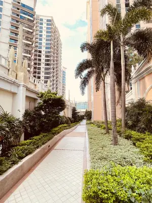a walkway in a city with palm trees and buildings at Venetian Panorama BGC Venice Grand Canal Apart ment, 4 Bedrooms, for 10 Guests in Manila