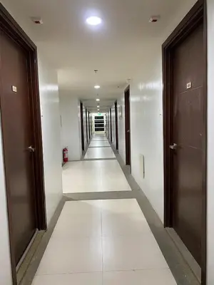 a hallway of a building with white floors and doors at Elegant Escape Milano Bacoor Cavite in Bacoor