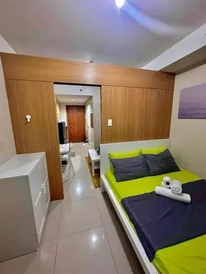 a bedroom with a bed with two towels on it at Shell Residence Mall of Asia in Manila