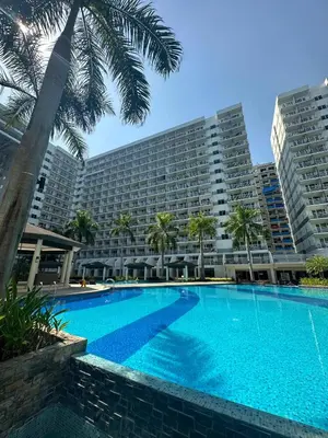 a large swimming pool in front of a large building at Shell Residence Mall of Asia in Manila