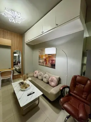 a living room with a couch and a table at Comfy Cozy Staycation in Manila