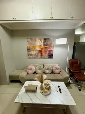 a living room with a couch and a table at Comfy Cozy Staycation in Manila