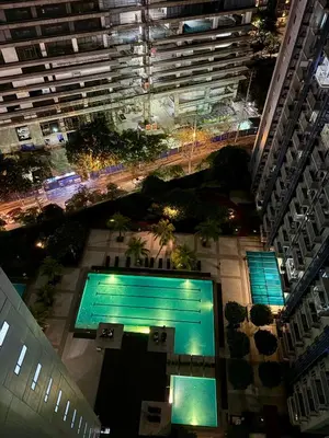 an overhead view of a pool in a city at night at Comfy Cozy Staycation in Manila