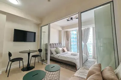 a living room with a bed and a table at Bahamas Tower Azure Urban Resort Residences by Nestled Nook in Manila