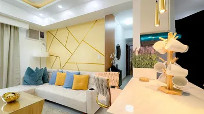 a living room with a white couch and a table at CYLOS PLACE Manhattan Araneta Center 2BR with BALCONY in Manila