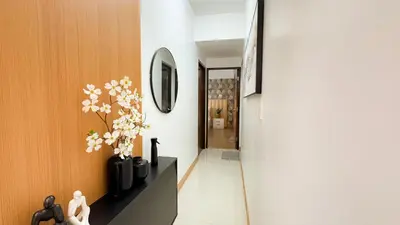 a hallway with a vase of flowers and a mirror at CYLOS PLACE Manhattan Araneta Center 2BR with BALCONY in Manila