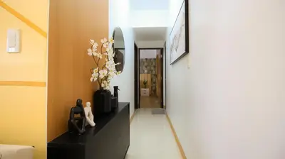 a hallway with a dresser with a mirror and flowers at CYLOS PLACE Manhattan Araneta Center 2BR with BALCONY in Manila