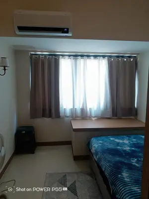 a bedroom with a bed and a window with curtains at SMDC Field REsidences condo unit in Manila