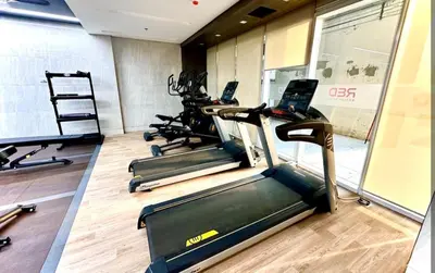 a gym with several treadmills and laptops in it at StayCation at Red Residence in Manila