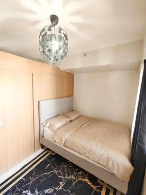 a small bedroom with a bed and a chandelier at StayCation at Red Residence in Manila