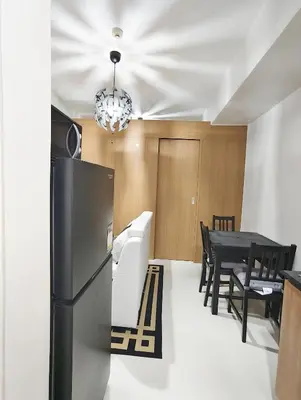 a kitchen with a black refrigerator and a table at StayCation at Red Residence in Manila
