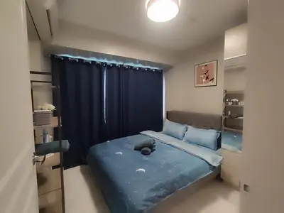 a bedroom with a blue bed with a black curtain at BP1043 Pool View Staycation Paranaque Pasay in Manila