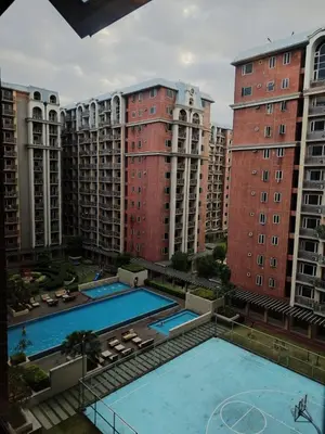 a view of two swimming pools with tall buildings at BP1043 Pool View Staycation Paranaque Pasay in Manila