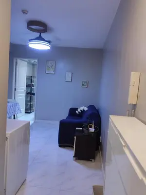 a living room with a couch and a blue wall at BP1043 Pool View Staycation Paranaque Pasay in Manila