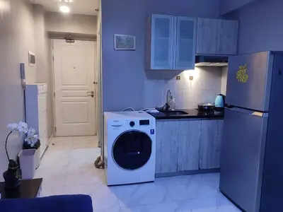 a kitchen with a washing machine and a refrigerator at BP1043 Pool View Staycation Paranaque Pasay in Manila