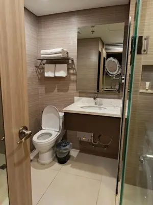 a bathroom with a toilet and a sink at Aura Luxe Stays at BCCT in Manila