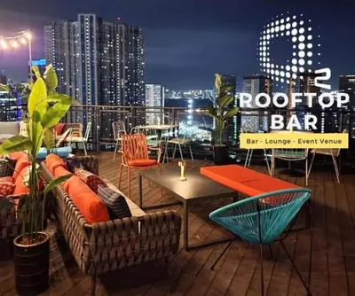 a rooftop bar with chairs and tables and a city skyline at Aura Luxe Stays at BCCT in Manila