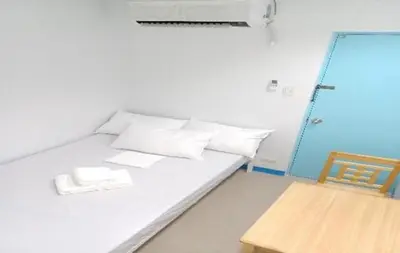 a room with a bed and a wooden chair at AIr Hub Transient in Manila