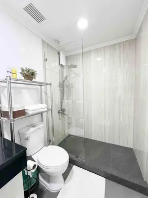 a bathroom with a toilet and a glass shower at Home Away From Home in Manila