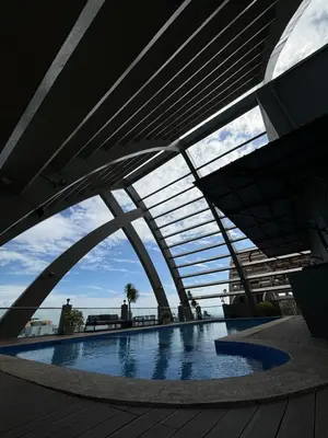 a building with a swimming pool with a bridge at Trendy 3BR Loft Condo along EDSA in Manila