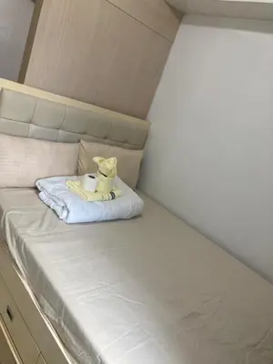 a stuffed animal is sitting on a bed at Sea Residence Tower EF by Theresa P in Manila