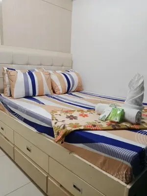 a bed with drawers and pillows on it at Sea Residence Tower EF by Theresa P in Manila
