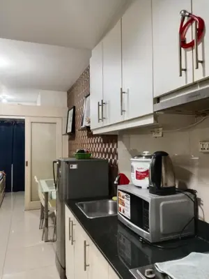 a kitchen with a sink and a microwave at Sea Residence Tower EF by Theresa P in Manila