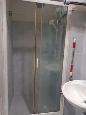 a shower with a glass door next to a sink at Sea Residence Tower EF by Theresa P in Manila