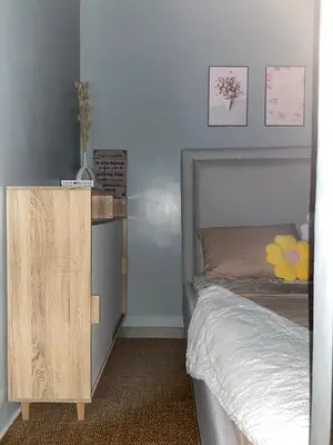 a bedroom with a bed and a wooden dresser at Balay Hayahay Staycation in Manila