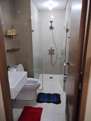 a bathroom with a shower and a toilet and a sink at Kylie and Drew Room Near Airport in Manila