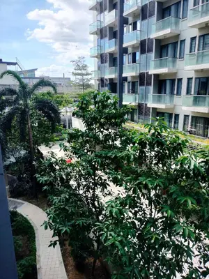a building with a tree in front of a building at Kylie and Drew Room Near Airport in Manila