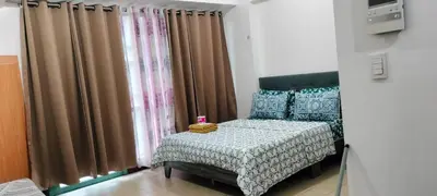 a bedroom with a bed and a window with curtains at Kylie and Drew Room Near Airport in Manila