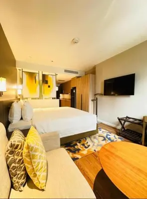 a hotel room with a bed and a table at Novotel Executive Suite - Acqua Manila 2905 in Manila