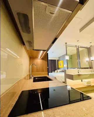 a kitchen with a sink and a bed in a room at Novotel Executive Suite - Acqua Manila 2905 in Manila
