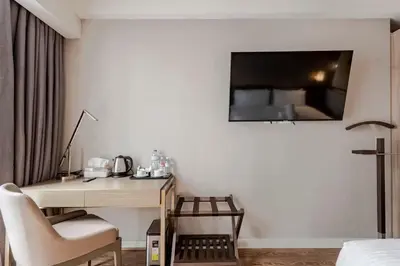 a room with a desk and a television on a wall at Novotel Executive Suite - Acqua Manila 2905 in Manila