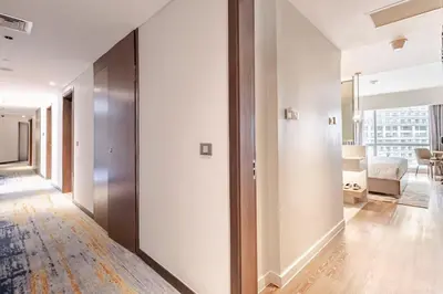 a hallway with white walls and a living room at Novotel Executive Suite - Acqua Manila 2905 in Manila