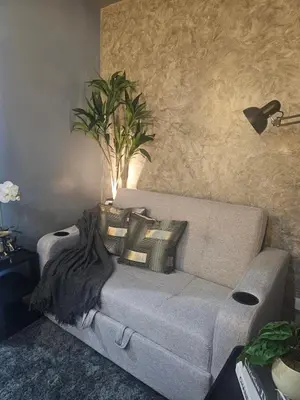 a couch with pillows on it in a living room at Sakura Suites At Mall of Asia Near Airport in Manila