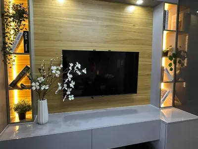 a living room with a tv on a wall at Sakura Suites At Mall of Asia Near Airport in Manila