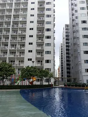 a swimming pool in front of two tall buildings at Shore residences tower A in Manila