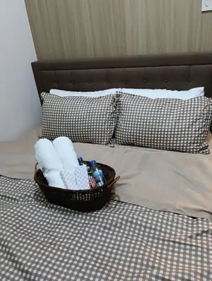 a basket of towels on a bed with pillows at Shore residences tower A in Manila