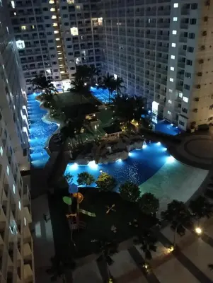 an overhead view of a large pool in a city at night at Shore residences tower A in Manila