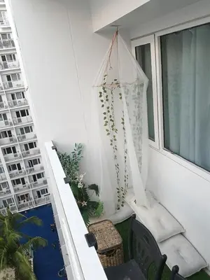 a balcony with a swing and a window at Shore residences tower A in Manila