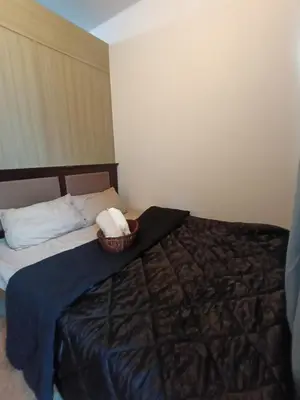 a bedroom with a bed with a basket of towels at Shore residences tower A in Manila