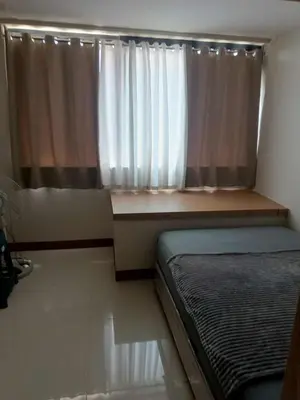 a bedroom with a bed and a window with curtains at SMDC Field REsidences condo unit in Manila