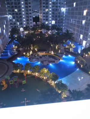 an aerial view of a large pool at night at Very Central Mall of Asia Manila Apartment in Manila