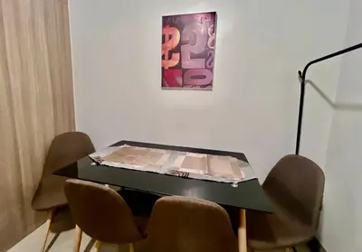 a table with chairs in a room with a painting at MOA - Walking Distance to Mall Cheap Accommodation in Manila